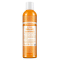 A bottle of Dr. Bronners Citrus Organic Hair Rinse stands upright. The orange bottle features detailed text about its conditioning benefits with shikakai for shiny, silky hair. Label promotes fair trade and organic certification [8 oz]